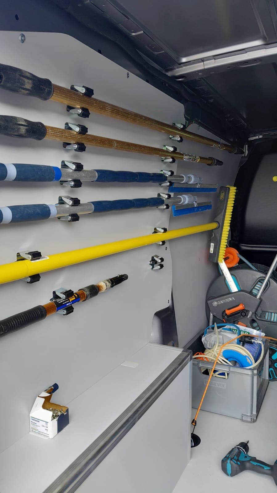 Netjes georganiseerde telescopische stelen en materiaal in de bestelwagen