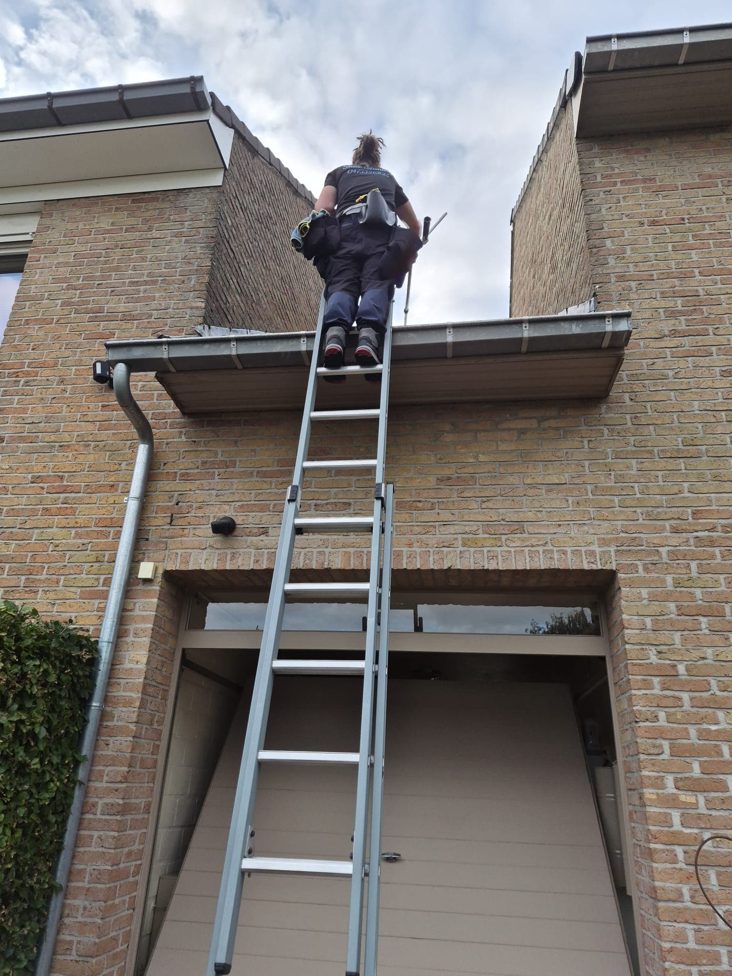 Medewerker van Shaz Cleaning op een ladder bij een woning